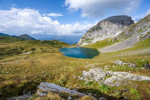 Mountain hut Obstanserseehuette at the mountain lake Obstansersee, behind rocky mountain peak