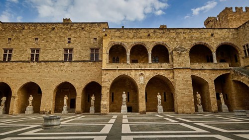 Super wide angle shot, castle courtyard with arcades, statues and a chequered floor under a cloudy