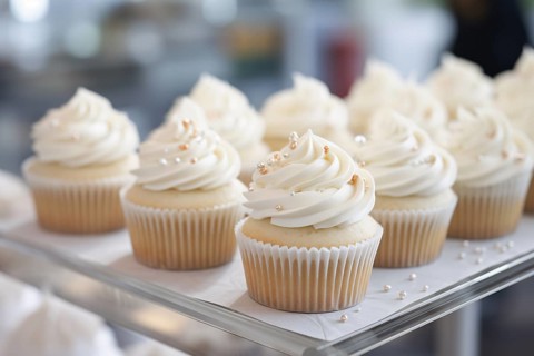 Wedding cupcakes with white frosting and sugar sprinkles. AI generated