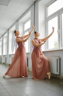 Two ballet dancers rehearsing moves in the hallway