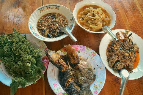 Overhead view of an authentic traditional thai meal of grilled catfish or pla duk yang, sour bamboo