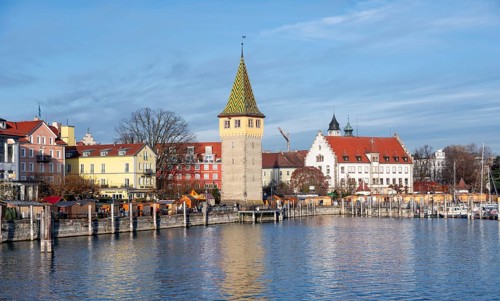 Harbour promenade with man tower, reflected in the lake, harbour, Lindau Island, Lake Constance,