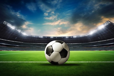 A soccer ball on a green field in soccer football stadium in evening with floodlights lights, AI
