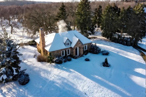 Aerial view of rustic vineyard cottage in a winter vineyard landscape with snow, AI generated