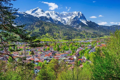 View of the village in spring in front of the Zugspitzgruppe 2962m in the Wetterstein Mountains,