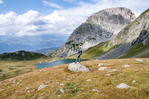 Mountaineer in front of mountain landscape, mountain hut Obstanserseehuette at the mountain lake