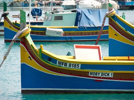 Several colourful fishing boats lying quietly in the harbour, many colourful fishing boats in a