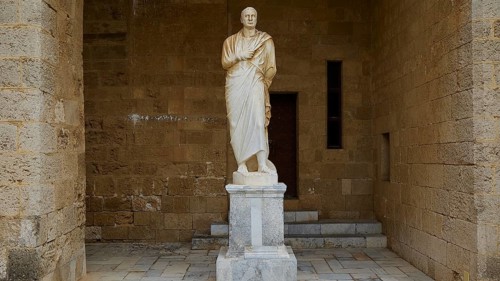Statue of a man in traditional garb stands on a pedestal in an alcove, statue from the 1st century