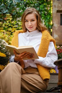 Young playful woman with a book outdoor
