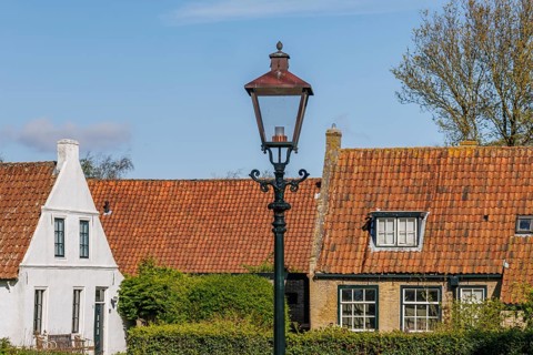 Historic houses with tiled roofs and a street lamp in a village in spring, historic houses in a