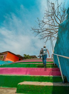 Man climbing multicolored steps. Rear view of a person climbing stairs, Nagarote