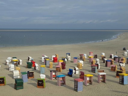 View of numerous colourful beach chairs on the wide beach under a cloudy sky, beach chairs and