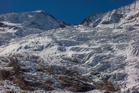 Glacier and snow covered mountain with bright blue sky, snow on high mountains in the alps, blue