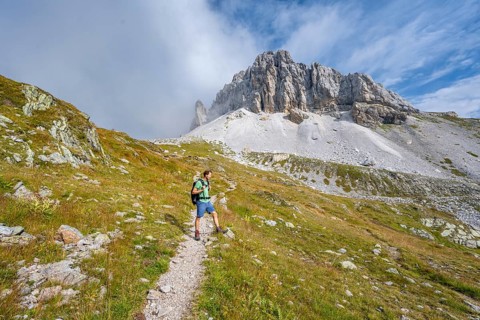 Mountaineer on a hiking trail, rocky summit of the Grosser Kinigat in the background, Carnic High