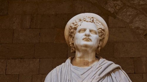 Portrait of an ancient statue with curls and lively facial features, Roman statue, courtyard, Grand