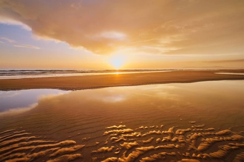 Atlantic ocean sunset with surging waves at Fonte da Telha beach, Costa da Caparica, Portugal,