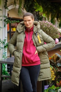 Gardener woman standing at a display case with potted autumn flowers