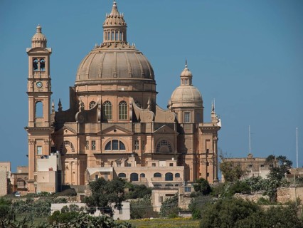 A large baroque basilica with a dome and an integrated clock tower made of sandstone, stand-alone
