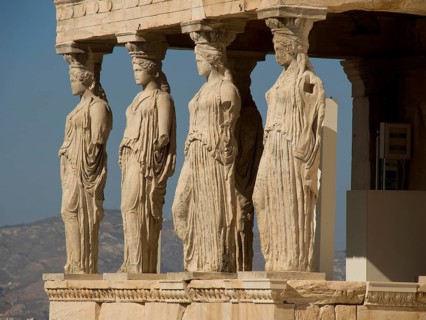 Statues of caryatids replacing columns on the Acropolis, historical columns and ruins on an ancient