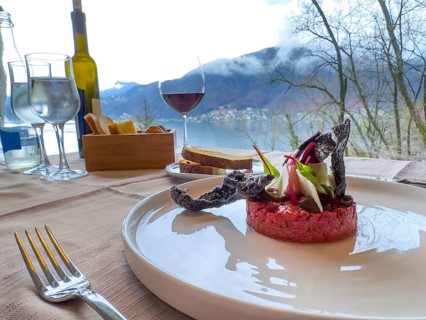 Restaurant Table with Bull Tartare with Black Charcoal Garlic and Tropea Onion with Parmesan Cheese