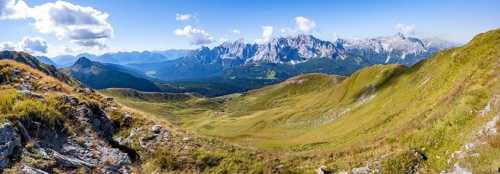 Green mountain meadows on a mountain ridge, mountain panorama, view of rocky mountain peaks of the
