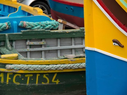 Close-up of colourful fishing boats lying next to each other in the harbour, many colourful fishing