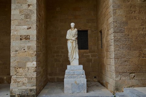 Antique statue of a character in traditional garb on a pedestal, torso from Rhodes, marble head