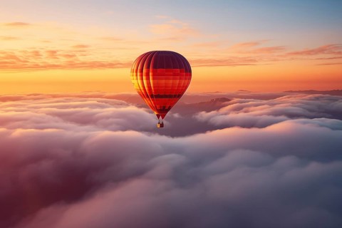 Colorful hot air balloon floats over a sea of clouds at sunset at sunset with orange and blue skies