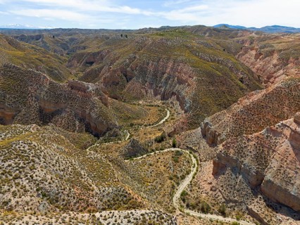 Wide views of hilly rocks and canyons, criss-crossed by winding paths, aerial view, Los Coloraos,