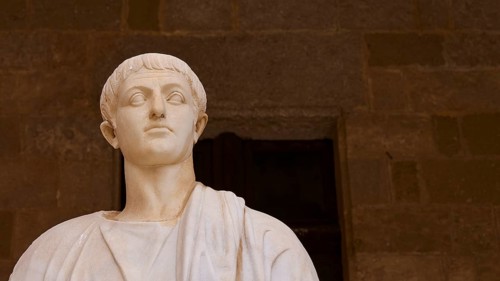 Ancient marble statue with distinct facial expression and headdress, statue from the 1st century