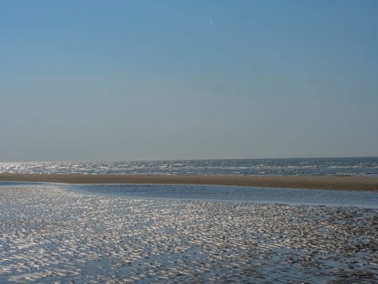 Spacious beach and calm sea under a clear blue sky, sparkling sea water at low tide on the beach,