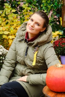 Outdoor portrait of pretty mid age woman surrounded with autumn flowers