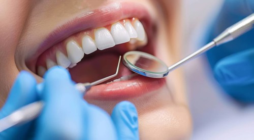 Woman with open mouth has teeth examined during checkup and fixed by a dentist in dental clinique,