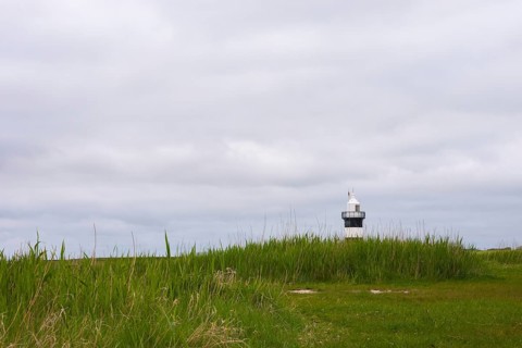 Black and white lighthouse near the North Sea resort Wremen, called 'Kleiner Preusse', behind high