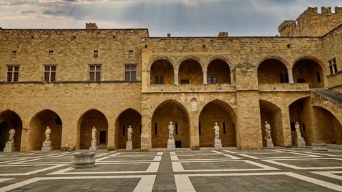 Large courtyard of a castle with statues and a chequered floor pattern, sky replaced, courtyard,