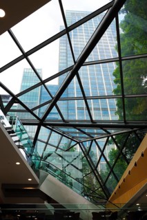 View through a glass building to the skyskyscrapers and trees, Modern Architecture, Canary Wharf,