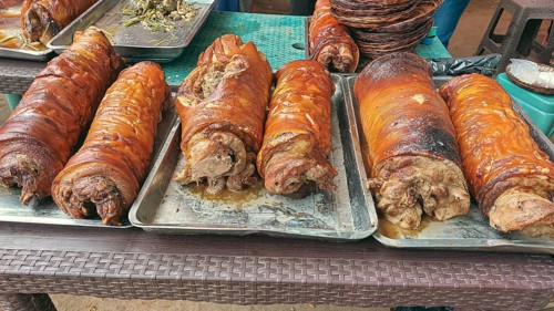 Rows of golden brown roasted pork belly or lechon liempo displayed at a street market showing an