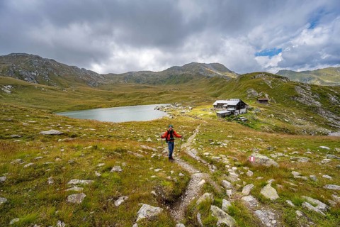 Mountaineer on a hiking trail to the mountain hut Obstanserseehuette at the mountain lake