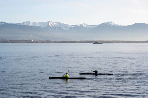 Kayakers paddling in Lake Constance in the evening light, snow-covered mountain peaks, Lindau