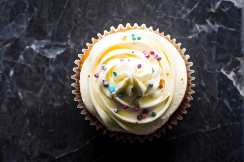 Cupcake with swirls of buttercream frosting in vanilla cream, AI generated