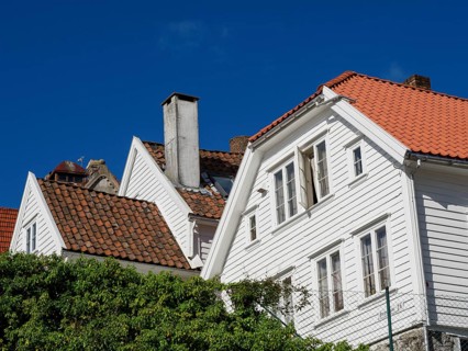 White houses with red tiled roofs, bright blue sky, windows with shutters, historical atmosphere,