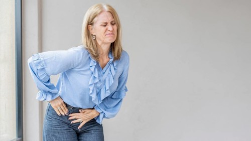 A blonde woman is suffering because she has appendix pain