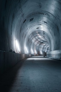An empty tunnel with neon lighting and metallic walls that conveys a dark and futuristic