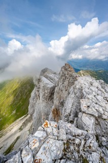 Rocky narrow summit ridge, cloudy mountain peak, summit of the Great Kinigat, Carnic Main Ridge,