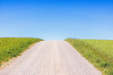 Gravel road on a hill a sunny summer day with a clear blue sky