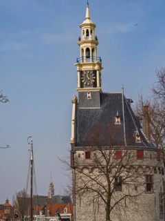 Historic clock tower with a view of the city and sailing boats against a blue sky, tower with a