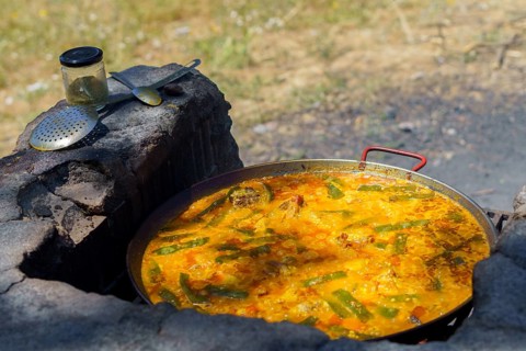 Close-up of a typical Spanish paella cooked over a wood fire in the countryside