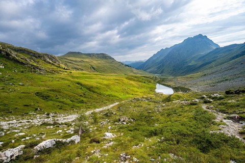 Mountain lake between green mountain meadows in a mountain valley, Oberer Stuckensee in the upper