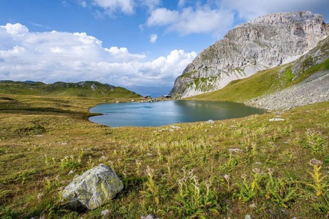 Mountain hut Obstanserseehuette at the mountain lake Obstansersee, behind rocky mountain peak