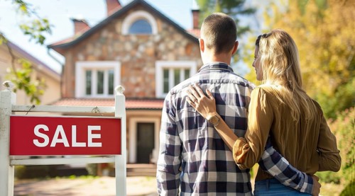 House for sale. Happy new buyer couple stand in front of modern luxury real estate intending to